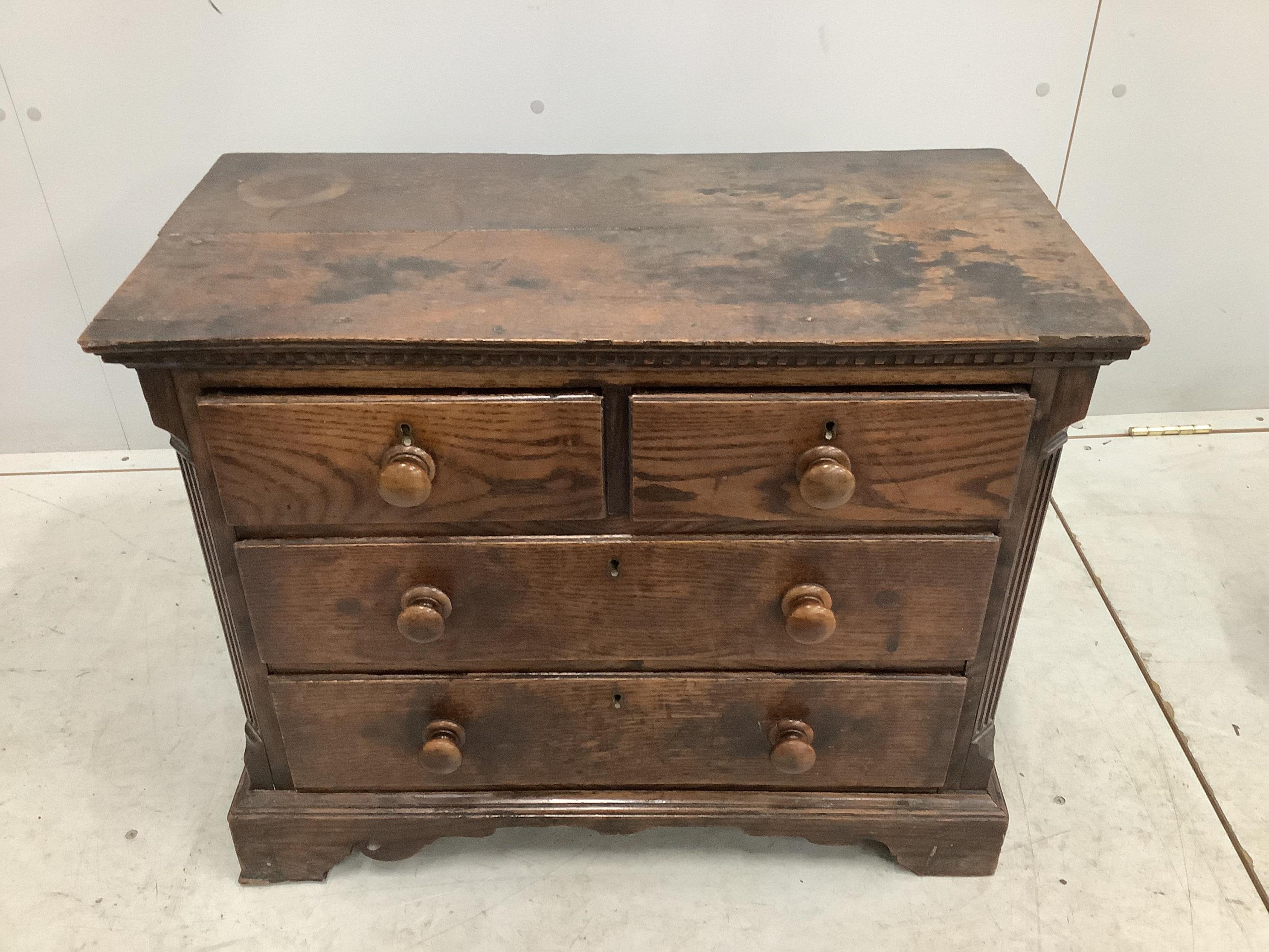 An 18th century miniature oak chest of two short and two long drawers, possibly child’s furniture, width 67cm, depth 34cm, height 55cm. Condition - fair, top timber join separated, one scroll detail missing from right br